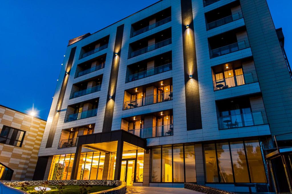 un edificio alto con muchas ventanas por la noche en Hotel President SPA, en Băile Felix