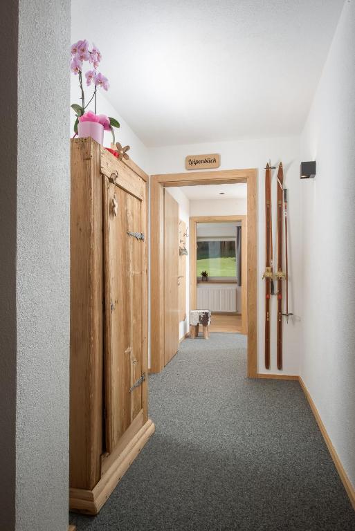 a hallway with a wooden door with flowers on top at Gästehaus Hain in Hochfilzen