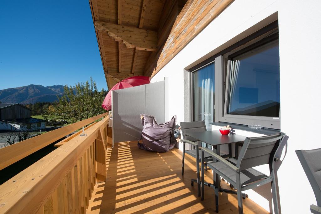 balkon ze stołem i krzesłami oraz oknem w obiekcie Gästehaus Hain w mieście Hochfilzen