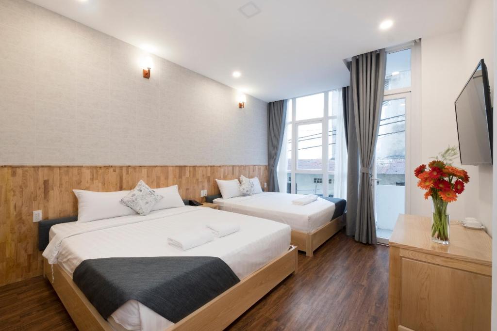 ホーチミン・シティにあるBeauty Houseのベッドが2つと窓があるホテルの部屋