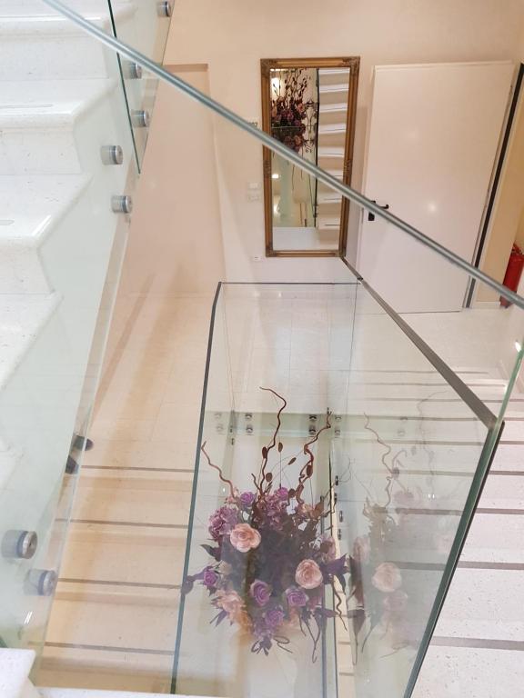 a glass staircase with a bouquet of flowers at Boutique Hotel Melissa in Poreč