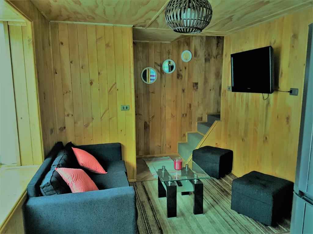 een woonkamer met een bank en een tv bij Cabañas Emma in Osorno