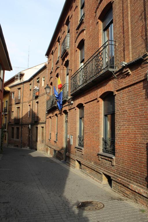 a brick building with a flag on a balcony at Albergue Muralla Leonesa in León