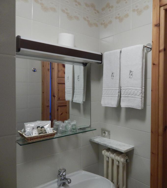 W łazience znajduje się umywalka, lustro i ręczniki. w obiekcie Hotel Valdotain w mieście Villeneuve