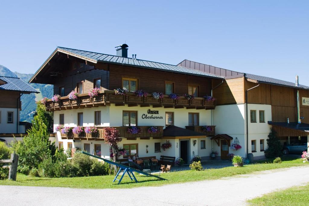a large building with a slide in front of it at Pension Oberhorner in Schladming