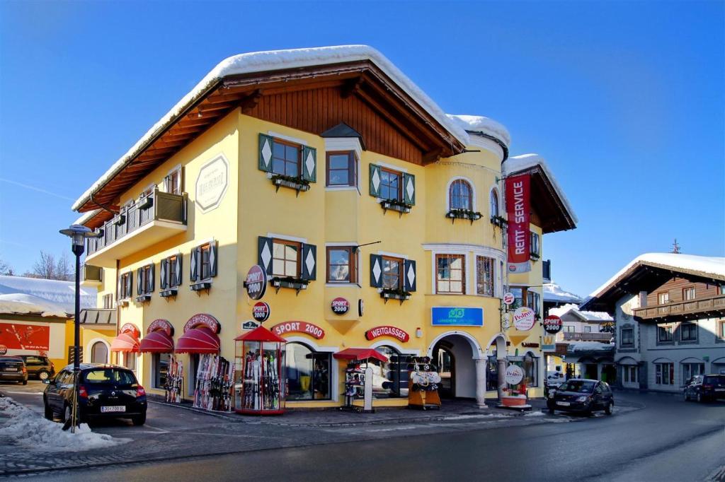 a yellow building on the side of a street at Haus am Platz - Weitgasser in Altenmarkt im Pongau