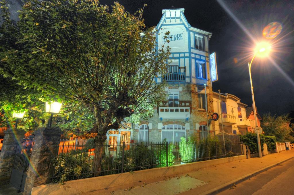 un edificio alto por la noche con luz de la calle en Hôtel Le Saint Pierre, La Baule-Escoublac en La Baule