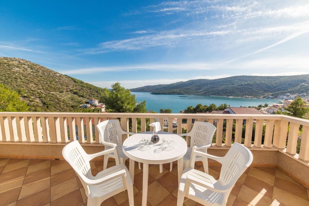 a table and chairs on a balcony with a view of a lake at Apartments Silvije in Marina