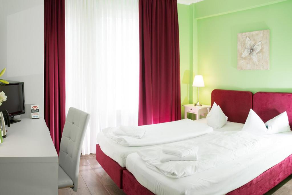 Schlafzimmer mit einem großen Bett mit einem roten Kopfteil in der Unterkunft Barcelona Bed & Breakfast in Düsseldorf