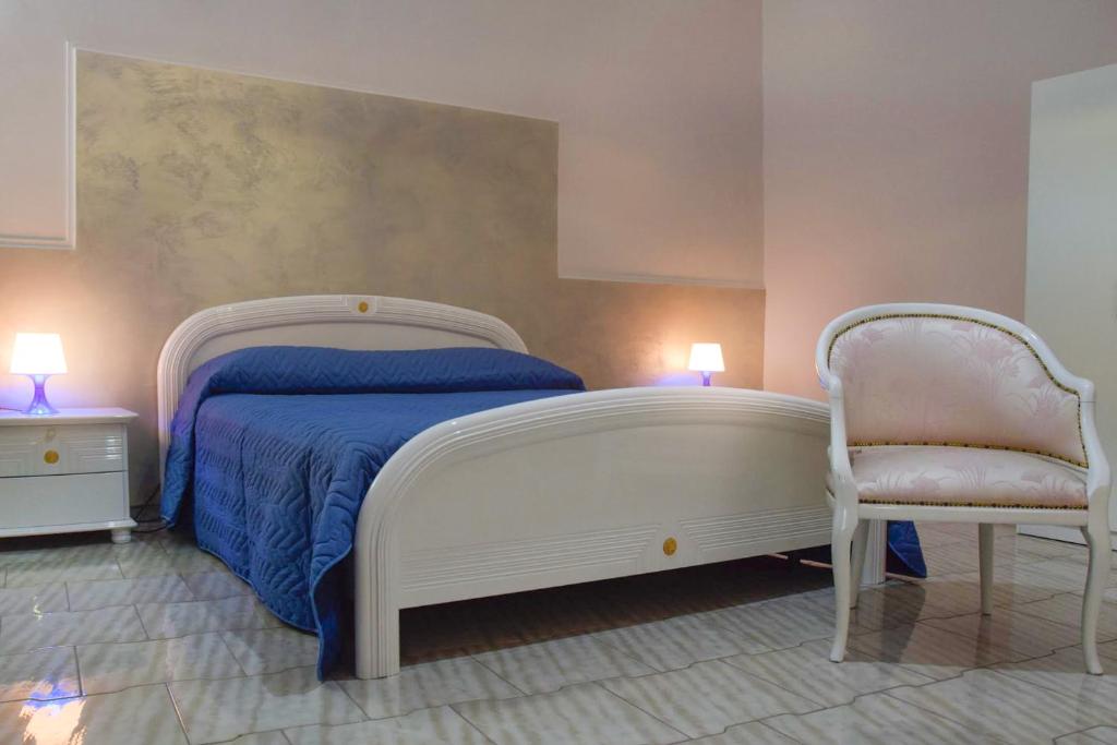 - une chambre avec un lit blanc et une chaise dans l'établissement B&B Al Castello di Lettere, à Lettere