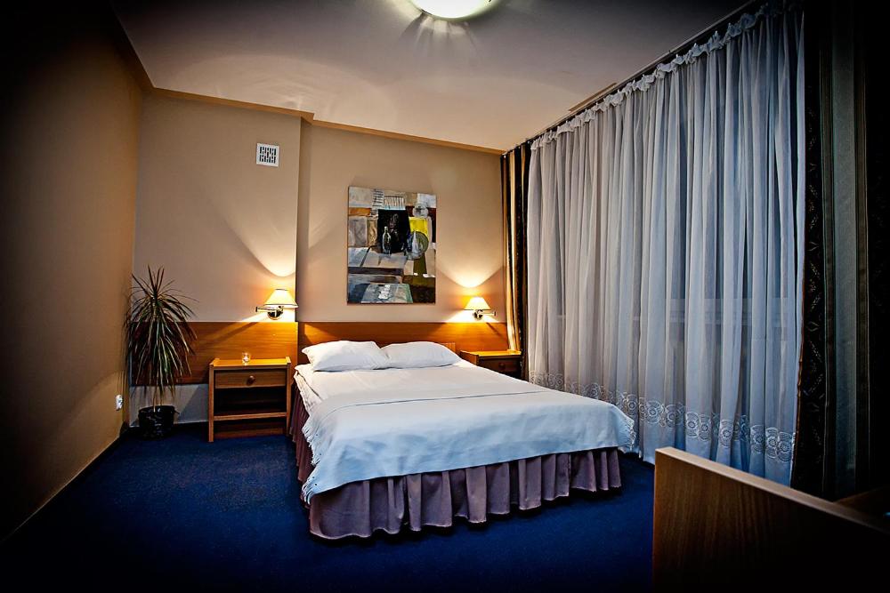 a hotel room with a bed and a window at Krechowiak in Augustów