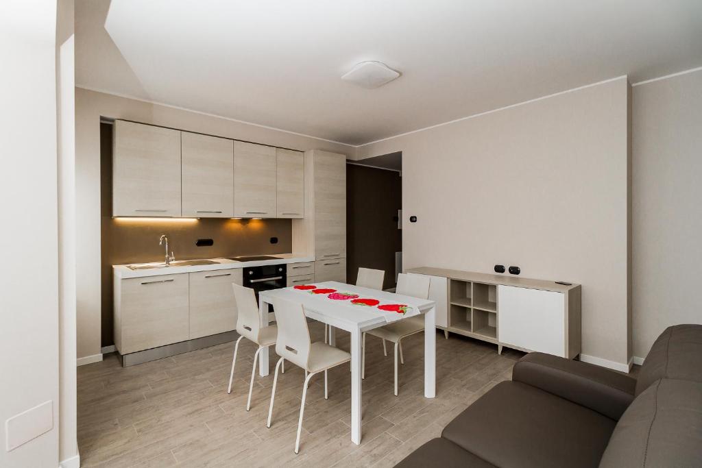 cocina y comedor con mesa blanca y sillas en Lake Como Apartments, en Lecco