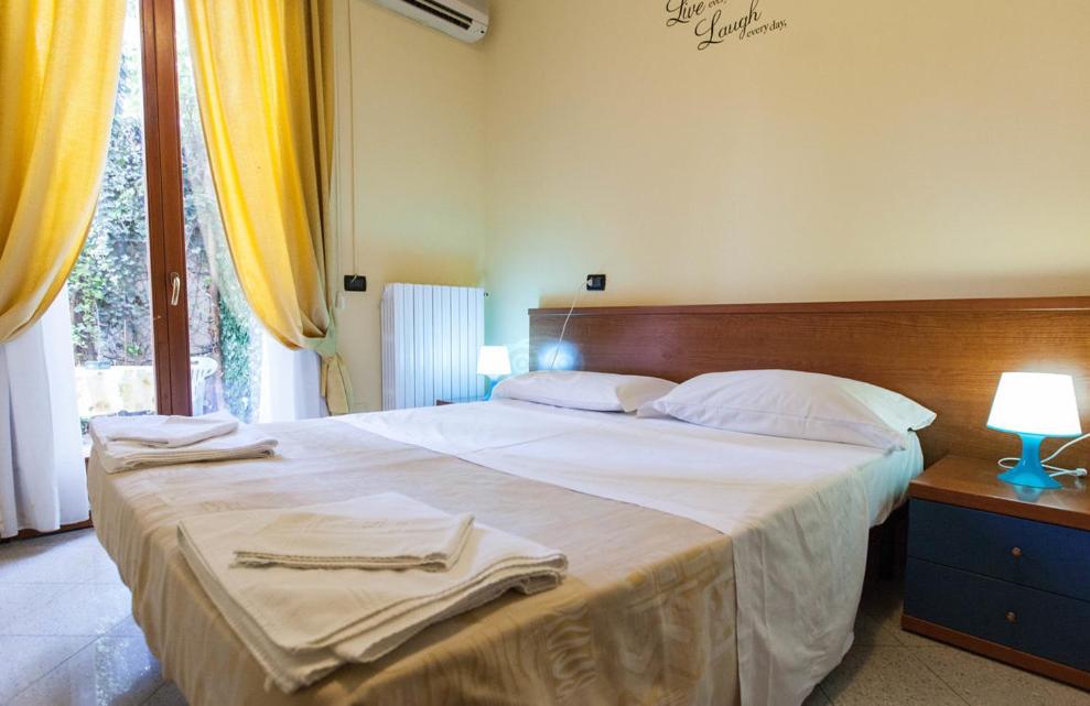- une chambre avec un grand lit et des serviettes dans l'établissement Hotel Greco, à Milan