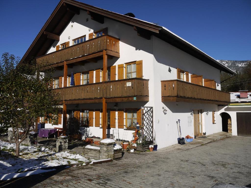 ein großes weißes Gebäude mit Holzbalkonen darauf in der Unterkunft Ferienwohnungen Kral in Grainau