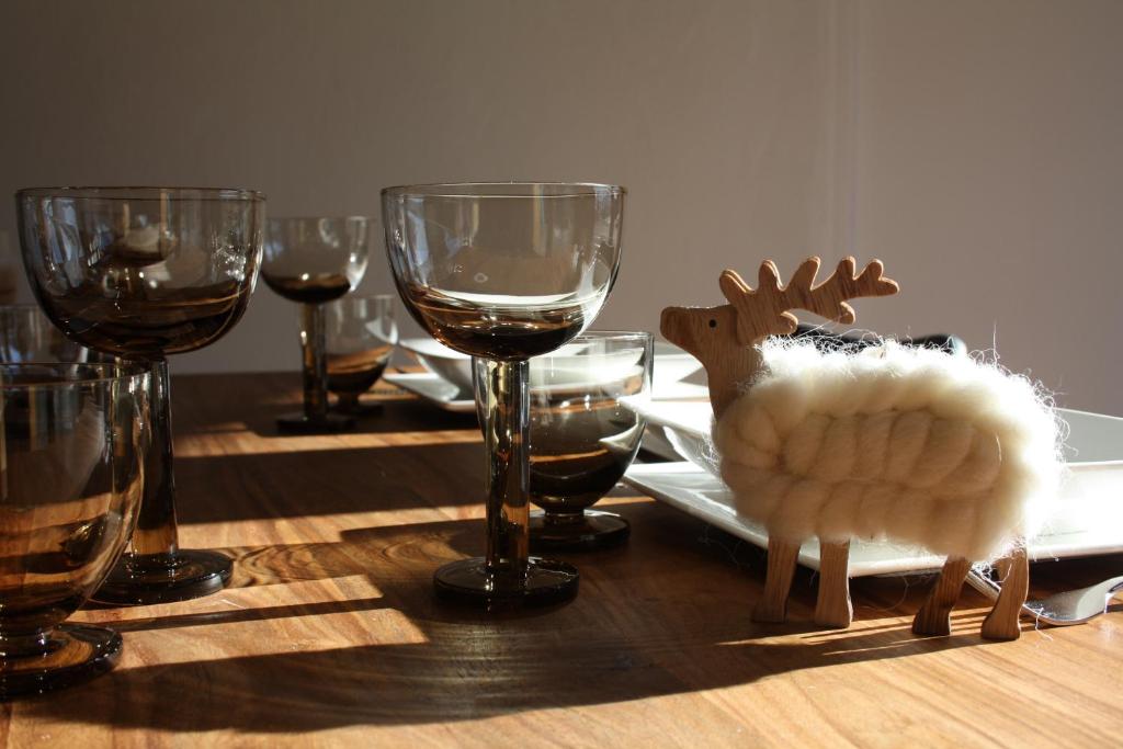 drewniana zabawka na drewnianym stole z kieliszkami do wina w obiekcie Le 995 w mieście Morzine
