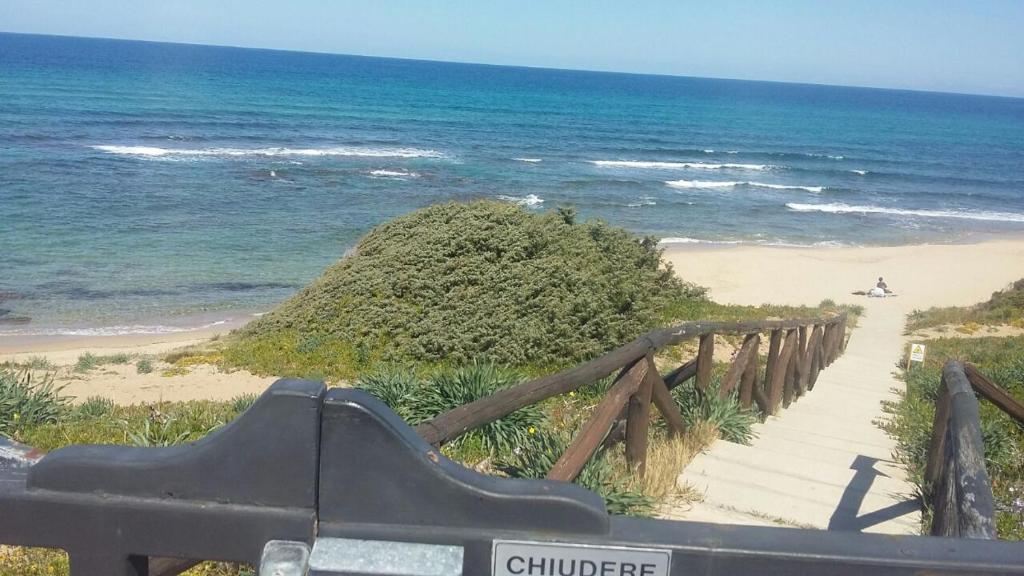 a wooden path leading to a beach with the ocean at La Perla del Mare in Castelsardo