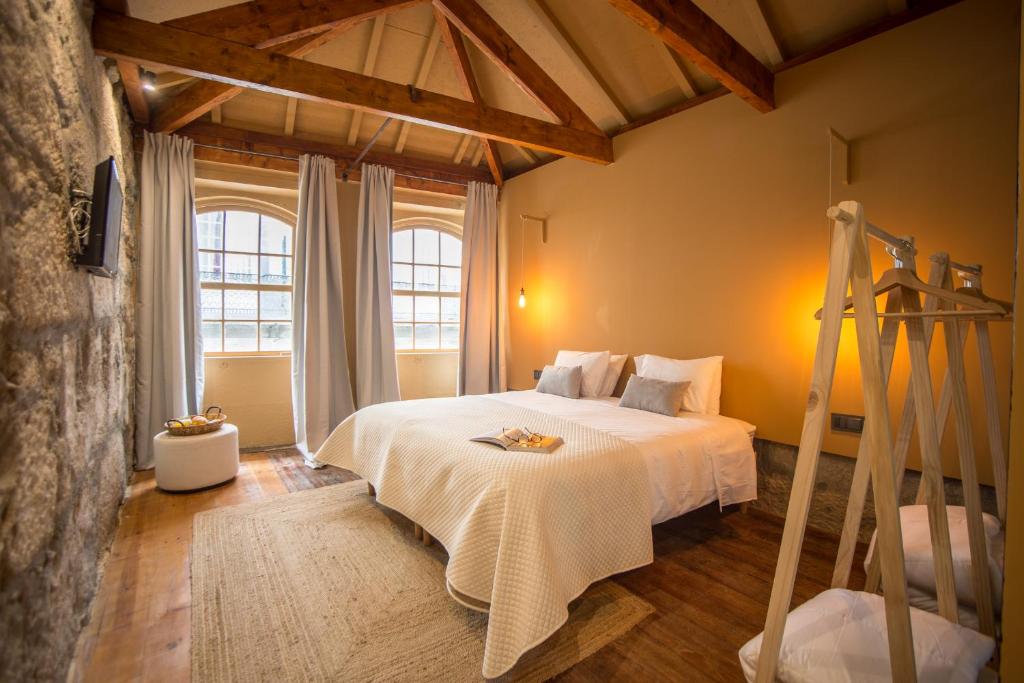 Un dormitorio con una cama blanca y una ventana grande. en Laurear Guest House, en Oporto