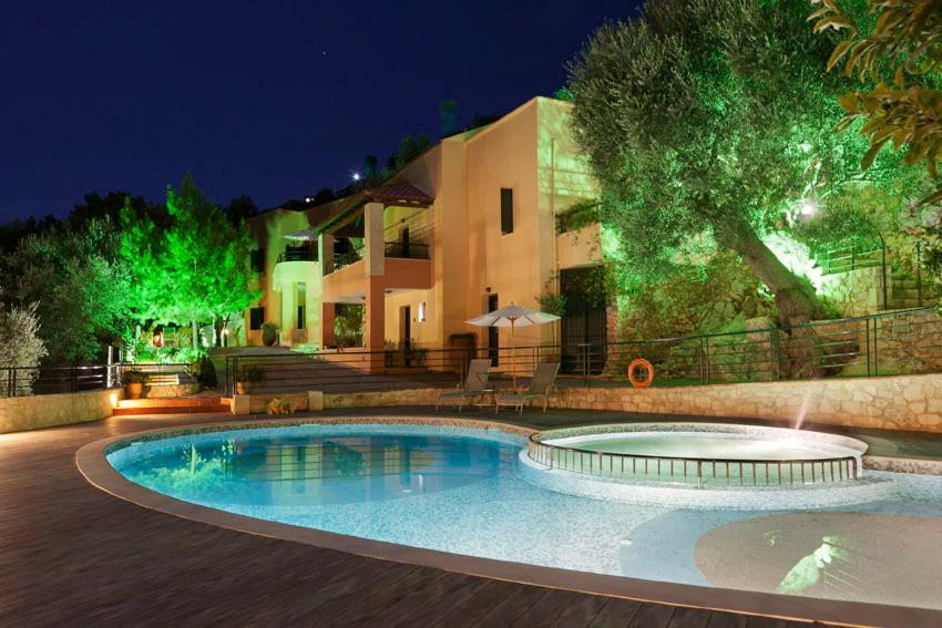 a swimming pool in front of a house at night at Agathes Traditional Houses in Kástellos