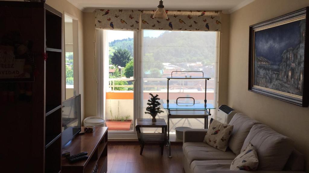 un soggiorno con divano e una grande finestra di Departamento 606 a Temuco
