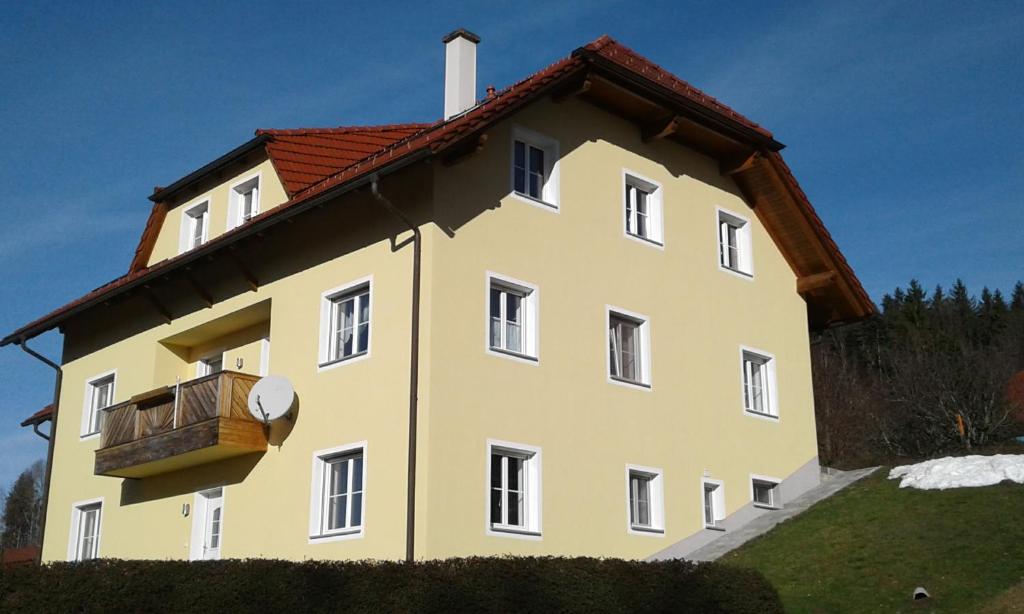 un gran edificio amarillo con balcón. en Ferienwohnung Susanne, en Ulrichsberg