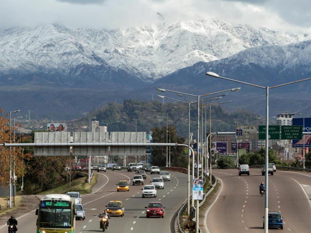una concurrida autopista con coches y autobuses y montañas cubiertas de nieve en Mistela Altos de Mendoza- Con Wifi- Con Servicio Gratuito al Aeropuerto o la Terminal- en Godoy Cruz