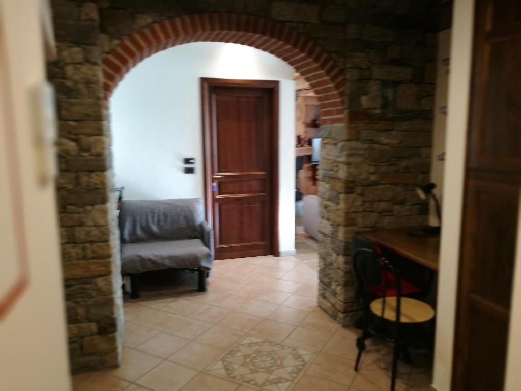 um arco que conduz a uma sala de estar com uma cadeira em Appartamento Rosa em Aosta
