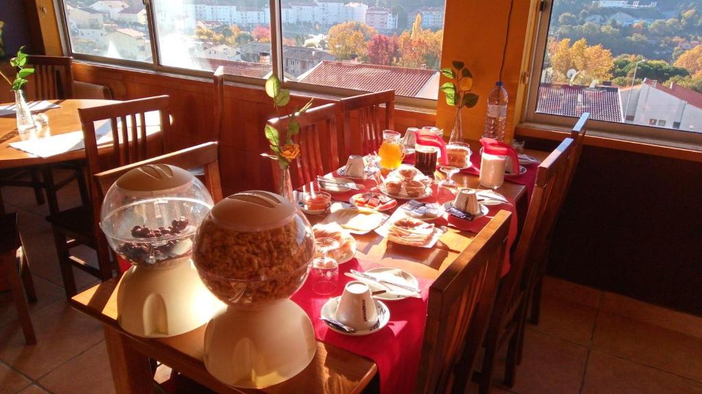 einen Tisch in einem Restaurant mit einem roten Tischtuch in der Unterkunft SEIA Apartamento Vista SERRA in Seia