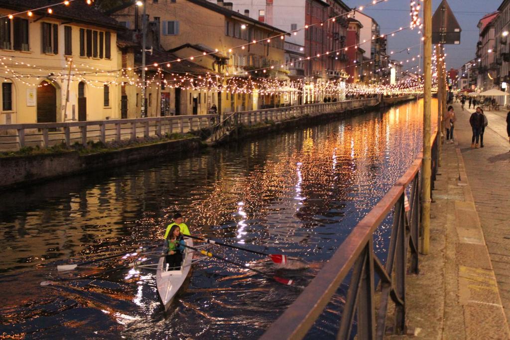 a boat in a canal with christmas lights at Da Ivano Milano Navigli in Milan