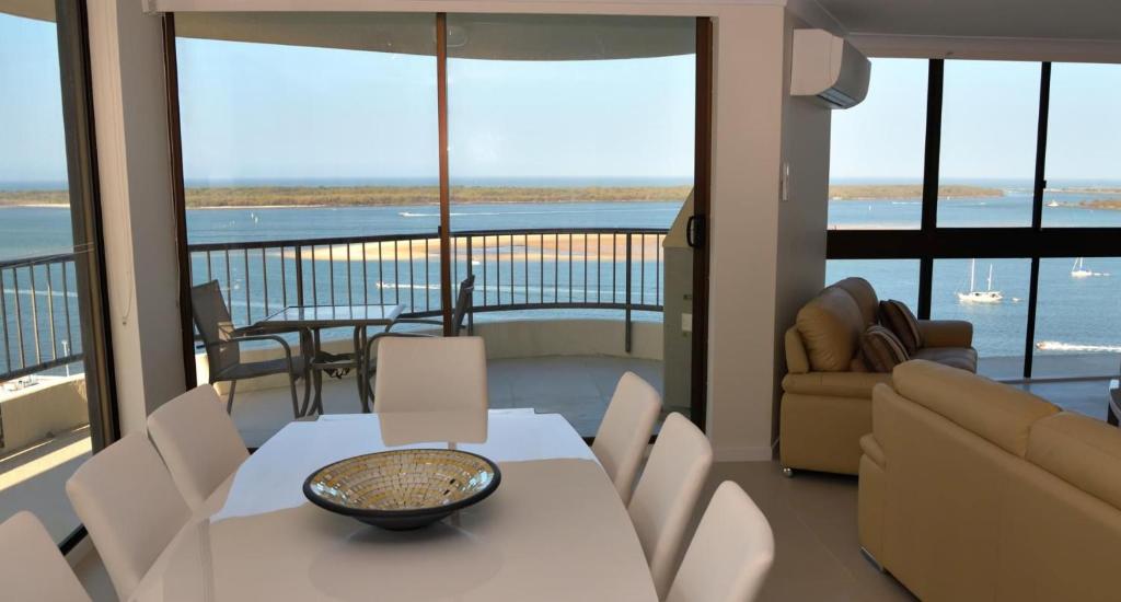 a living room with a table and chairs and a balcony at Broadwater Shores Waterfront Apartments in Gold Coast