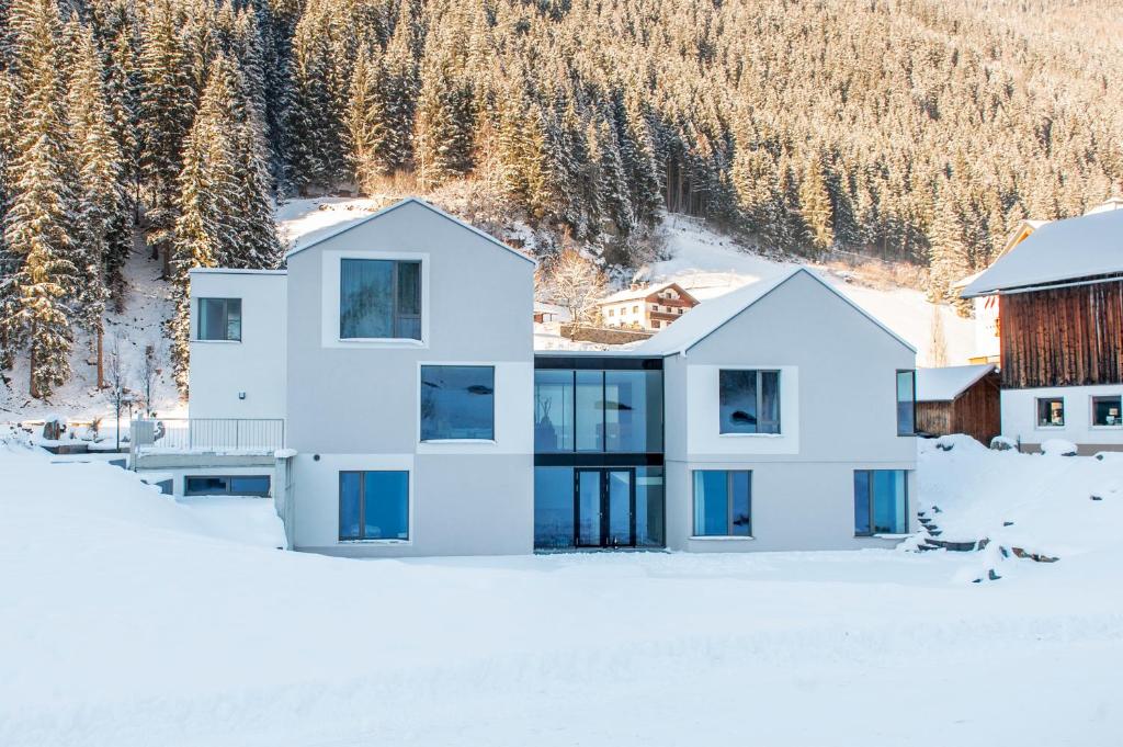 uma casa branca com janelas azuis na neve em Laudinella - Apart em See