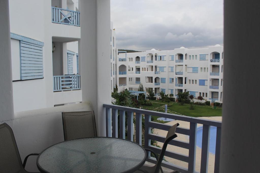 una mesa y sillas en un balcón con un edificio en Alcudia Smir 3 chambres, en M'diq