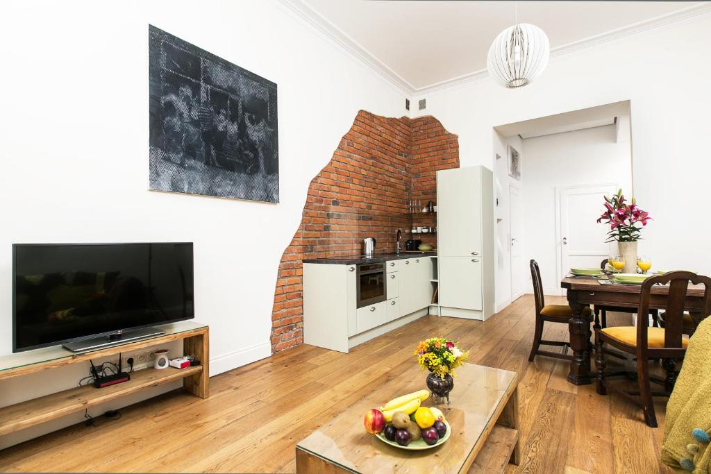 a living room with a television and a dining room table at Old Town Brigue Apartment by Otium in Krakow