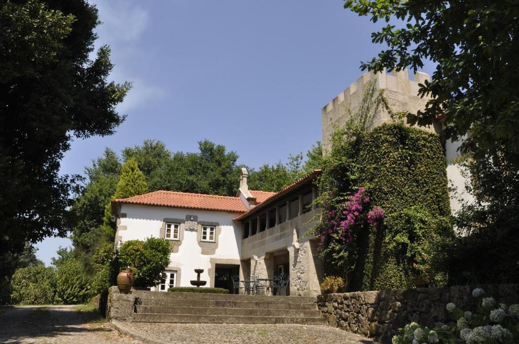 une maison blanche avec un mur et des escaliers dans l'établissement Quinta de Albergaria, à Facha