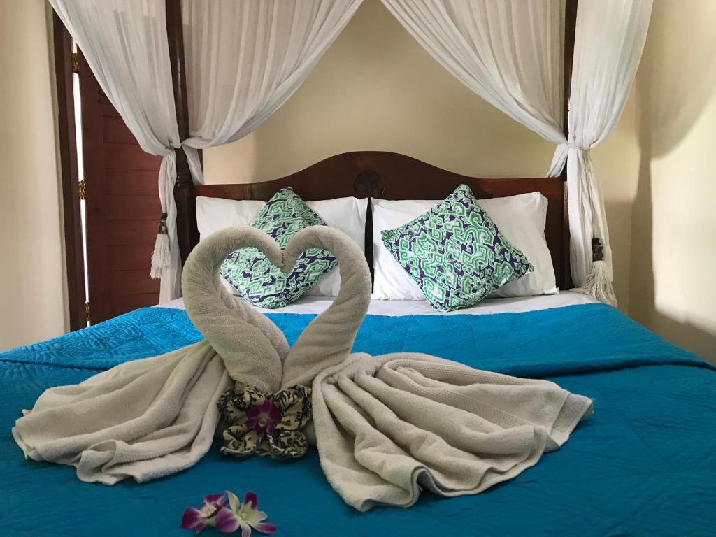 two swans wrapped in towels on a bed at Arya Homestay in Ubud