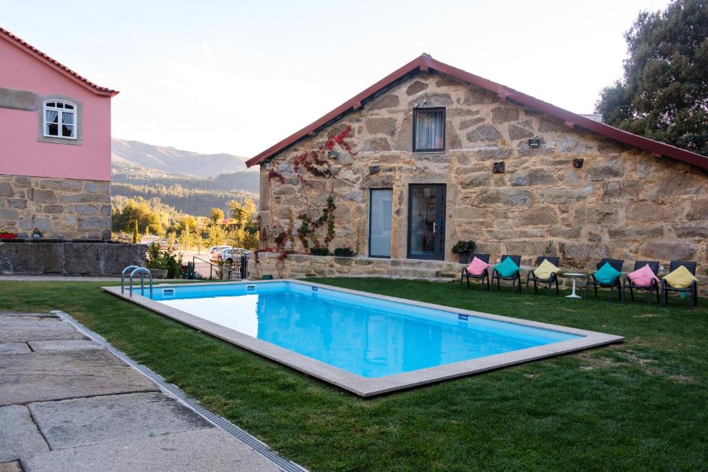 uma piscina em frente a uma casa de pedra em Quinta de Anterronde em Arouca