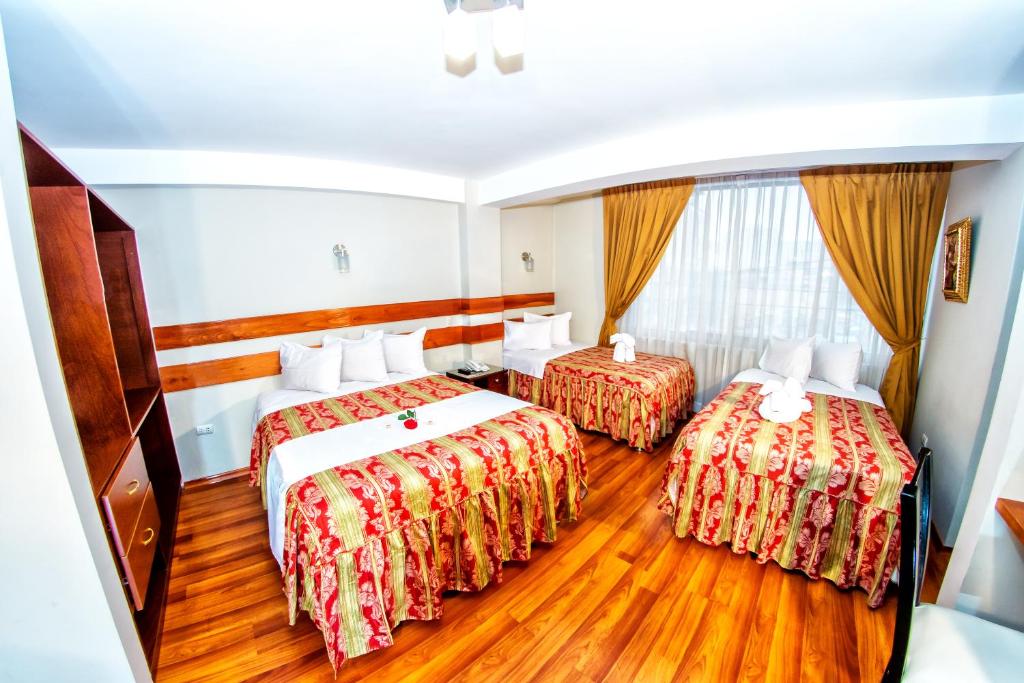 Habitación de hotel con 2 camas y TV en Hostal Los Andes, en Cusco