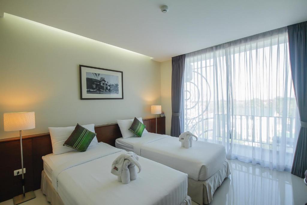 Postel nebo postele na pokoji v ubytování Baan Nilrath Hotel - SHA Extra Plus