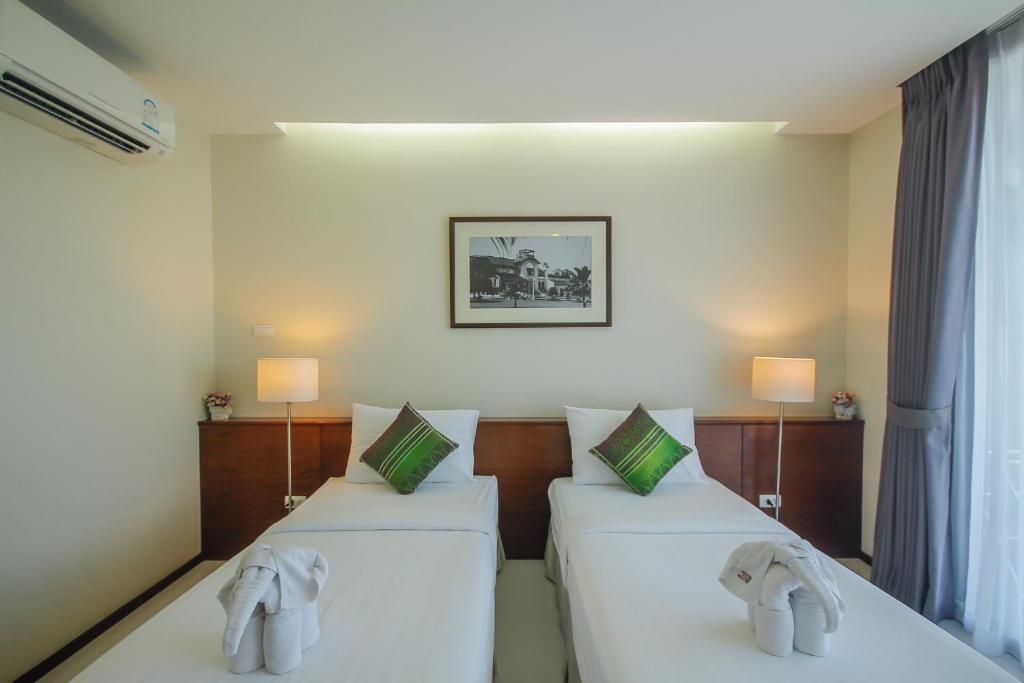Postel nebo postele na pokoji v ubytování Baan Nilrath Hotel - SHA Extra Plus