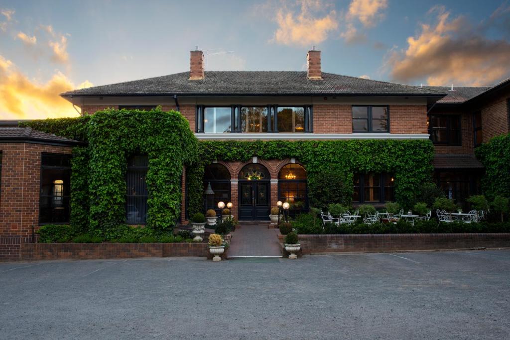 a brick house with ivy on the front of it at Berida Hotel in Bowral