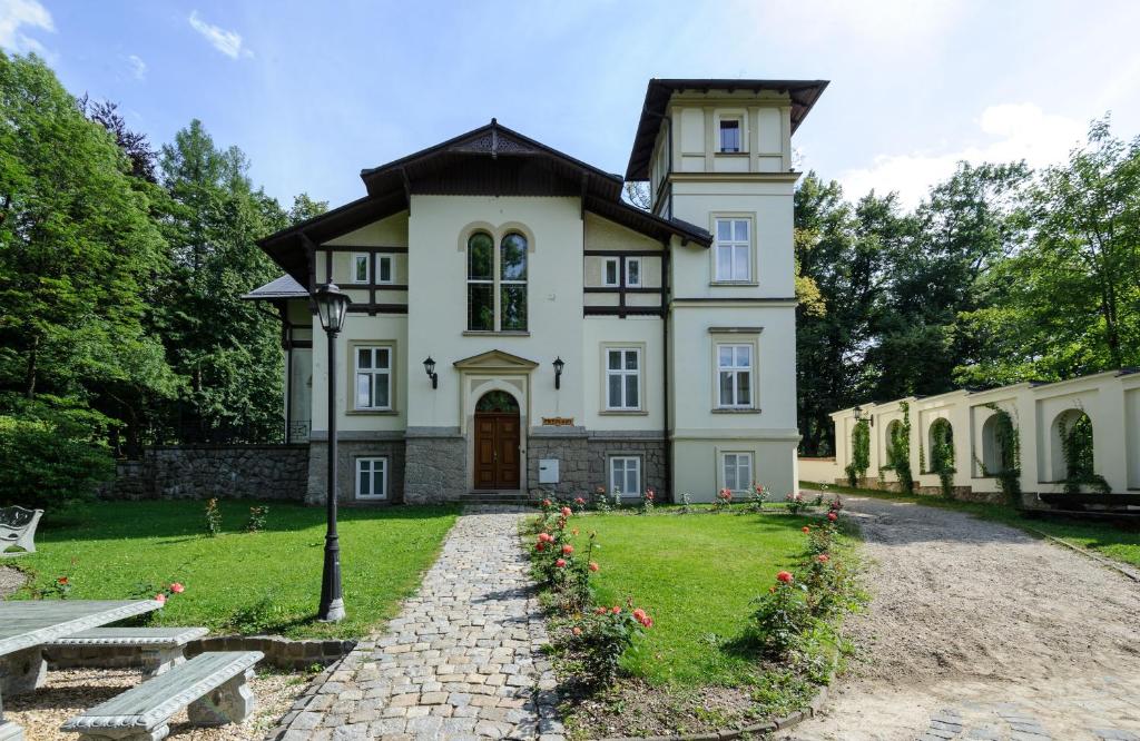 a large white house with flowers in the yard at Spa Resort Libverda - Villa Friedland in Lázně Libverda