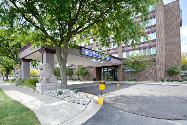 a building with a bear statue in front of it at Causeway Bay Hotel in Lansing