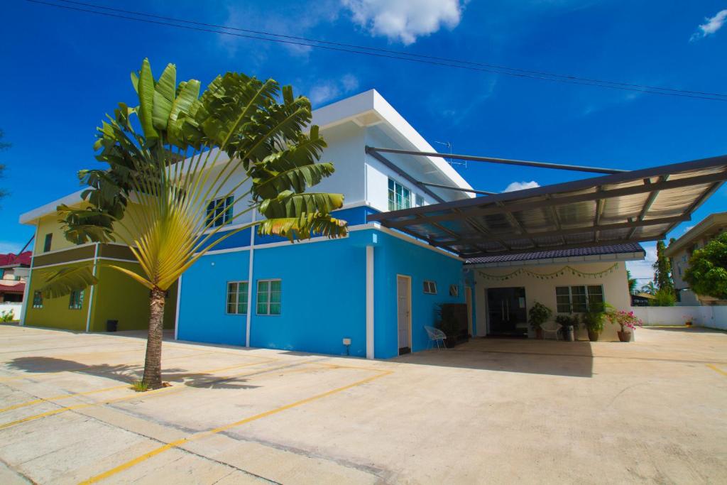 a blue building with a palm tree in front of it at Quality Guest House in Kuantan