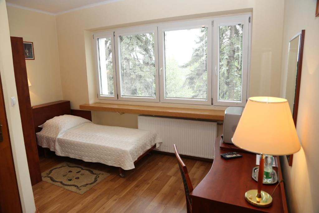 a bedroom with a bed and a desk and a window at ET Nocleg in Kalisz
