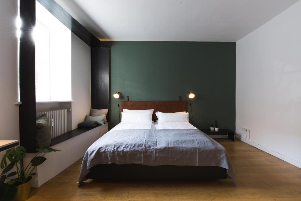 1 dormitorio con cama y pared verde en Vier Zimmer en Múnich