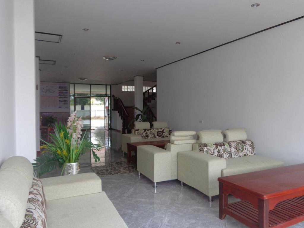 a waiting room with white chairs and a table at Phouluang Hotel in Phonsavan