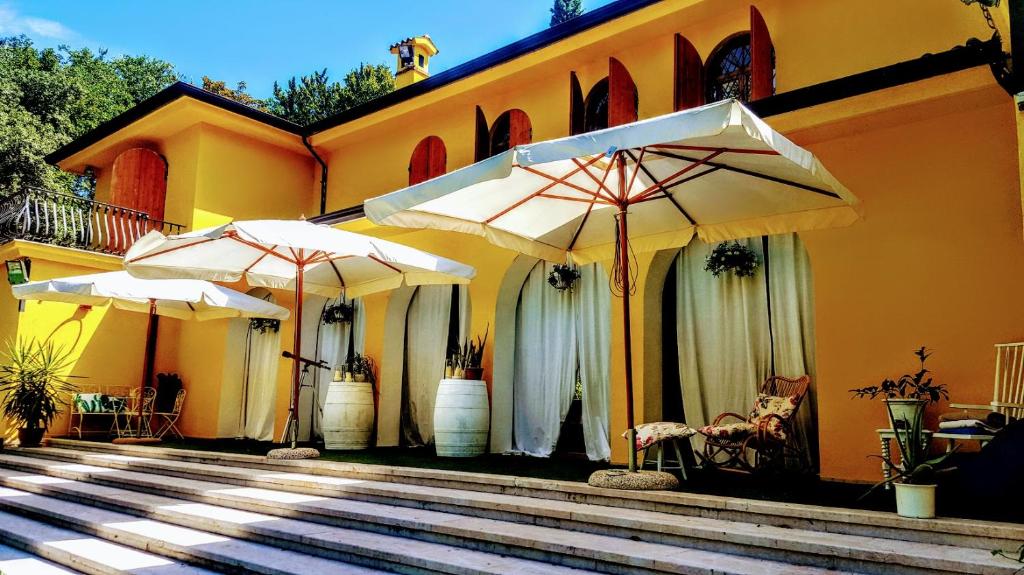 dois guarda-chuvas brancos sentados ao lado de um edifício em B&B Villa Graziella em Lazise
