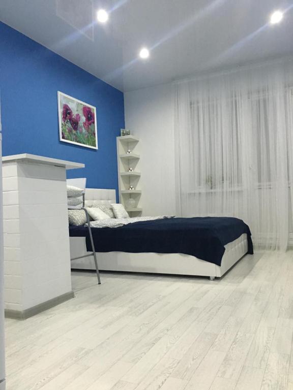 スルグトにあるApartment on Zakharovaの青い壁のベッドルーム1室(ベッド1台付)