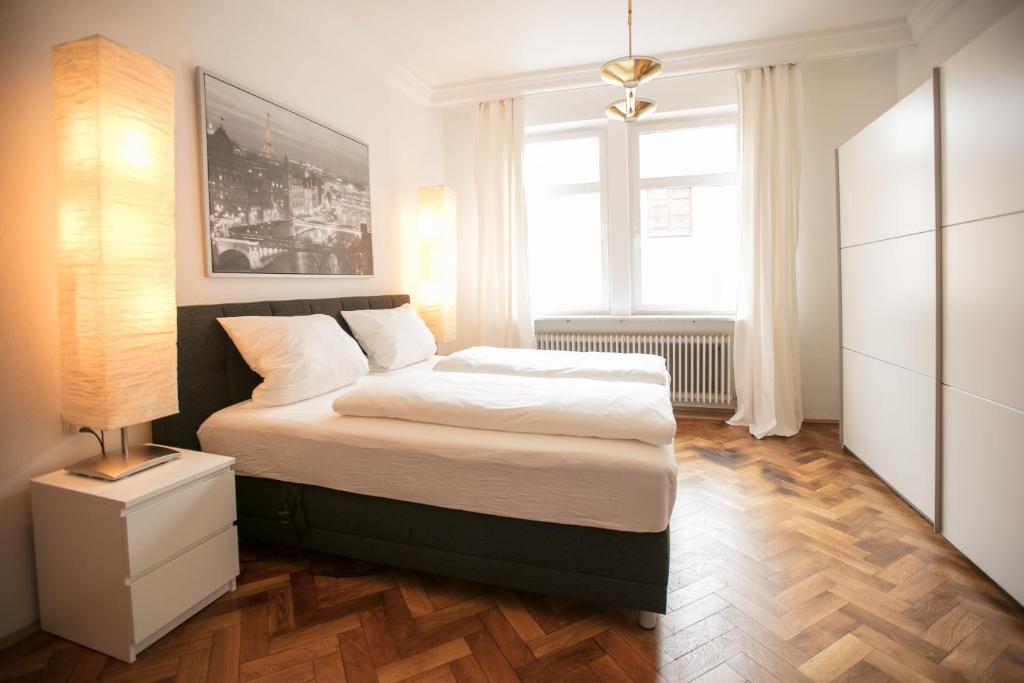 ein Schlafzimmer mit einem Bett und einem großen Fenster in der Unterkunft Palazzo am Dom in Regensburg