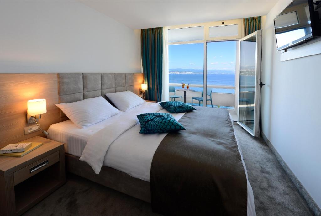 a bedroom with a large bed with a view of the ocean at Grand Hotel Adriatic II in Opatija