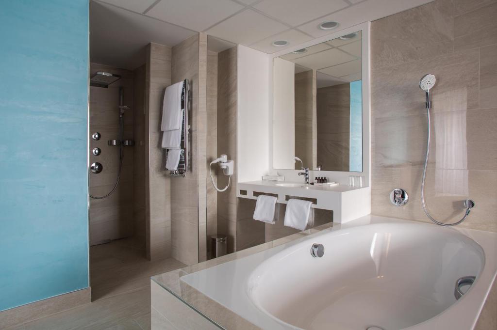 a bathroom with a large tub and a sink at Hotel Galatea in Mladá Boleslav